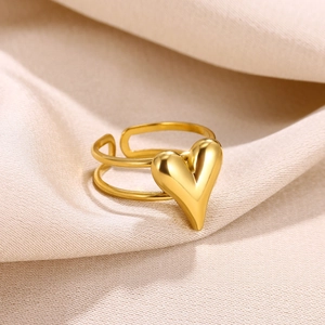 Detailed close-up of 18k gold plated open heart ring on textured beige fabric