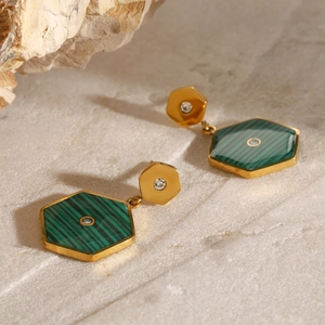 Detailed view of geometric gold earrings with green hexagonal malachite stone inserts