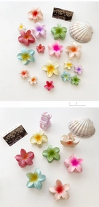 Detail of gradient plumeria hair claws in various sizes and vibrant candy colors
