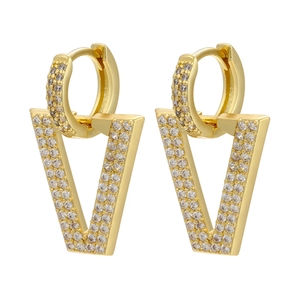 Macro shot of V-shaped gold earrings fully paved with sparkling cubic zirconia stones