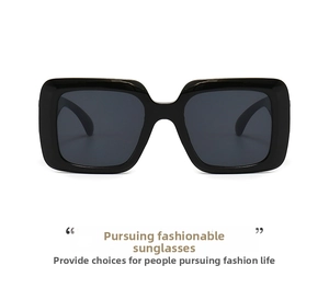 Detailed close-up of retro square black oversized sunglasses with gray lenses