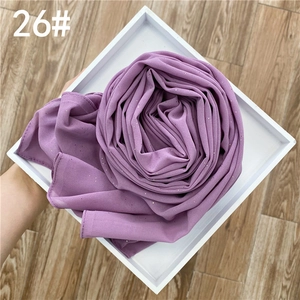 Détail du foulard en mousseline violette avec paillettes argentées et texture plissée
