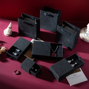 Elegant black glitter drawer jewelry gift box set with matching paper bag on red satin