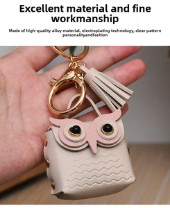 Detail of pink and white faux leather owl keychain with metal lobster clasp and fringe