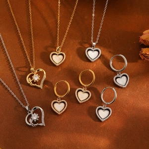 Mise à plat de bijoux cœur en or et argent avec colliers et boucles d'oreilles sur bois