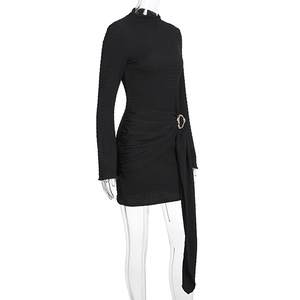 Détail de l'ourlet froncé avec boucle en métal doré sur robe noire à manches longues