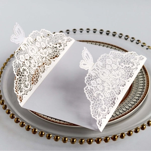 Elegant white laser-cut wedding invitation featuring intricate butterfly and floral patterns