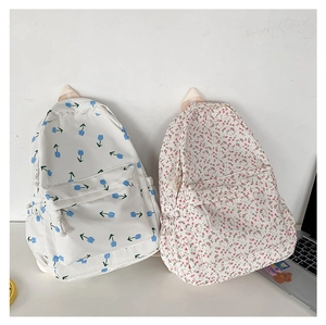 Close-up of floral pattern canvas backpacks with tulip and wildflower prints and side pockets