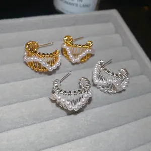 18k gold plated C-shaped hollow earrings with pearls and woven texture on velvet tray