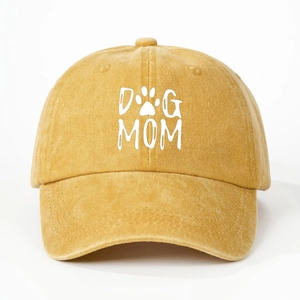 Gros plan détaillé du texte DOG MOM et de la patte sur la casquette en coton jaune délavé