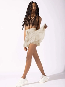 Detail view of tiered ruffles and delicate drawstring on cream high-waisted pleated skort