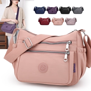 Detailed view of pink nylon mommy travel bag with multiple zipper pockets and logo