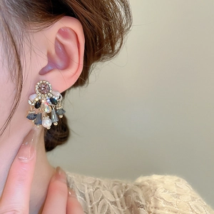 Close-up of model wearing luxury crystal fringe earrings with drop beads and pearls