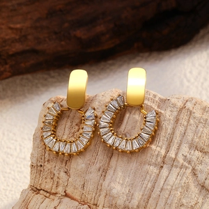 Macro shot of 18K gold plated U-shaped earrings with rectangular clear zircons
