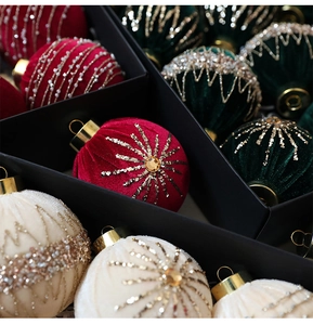 Detail of velvet Christmas balls with hand-beaded snowflake patterns in a gift box