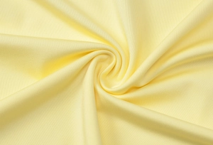 Macro detail of yellow backless dress fabric showing smooth texture and drape