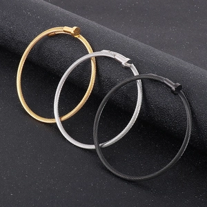 Close-up of cable wire bracelets with nail head clasp in gold, silver and black