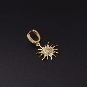 Detailed macro view of gold sun-shaped earring featuring micro-set sparkling cubic zirconia