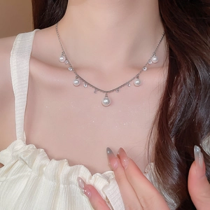 Close-up of pearl tassel necklace featuring five pearls and sparkling zircon pendants