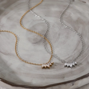 Elegant gold and silver stainless steel necklaces with marquise-cut zircon fans on ceramic