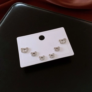 Macro detail of three pairs of silver bear stud earrings set with sparkling cubic zirconia