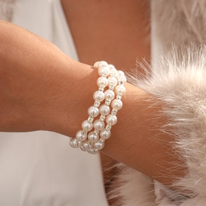 Close-up of triple-layer pearl bracelet with sparkling rhinestone spacers on wrist