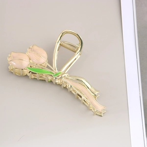 Détail de la pince à cheveux tulipe dorée avec pétales en émail rose et feuilles vertes