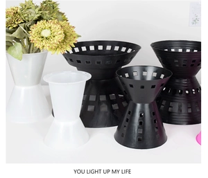 Detail of hourglass-shaped black and white plastic floral display buckets and pots