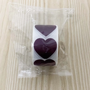 Macro-opname van een rol paarse hartvormige krasstickers in een plastic verpakking