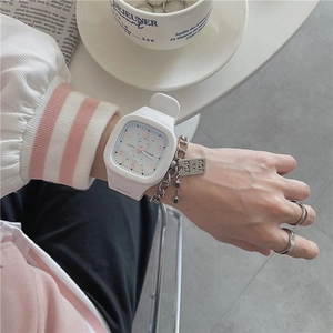 White square digital watch with silicone strap and quartz movement worn on a model's wrist