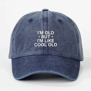 Detailed view of blue washed cotton baseball cap with white printed I'M OLD COOL OLD slogan