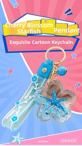 Detail of cherry blossom liquid keychain with blue starfish, sand and a gold ring