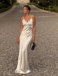 Close-up of elegant lace neckline on white satin slip dress with minimalist design