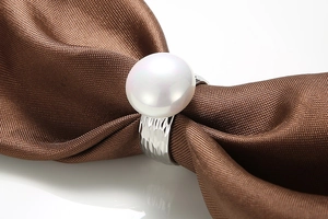 Macro shot of white pearl ring with silver-tone hammered texture on steel band
