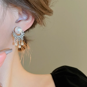 Detailed shot of pearl tassel earrings with micro-pave cubic zirconia on silver metal