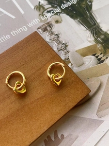 Elegant 925 sterling silver gold heart hoop earrings on a vintage wooden display stand
