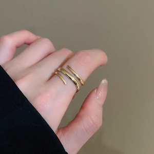 Close-up of three-layered spiral golden open ring with polished mirror finish on model