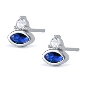 Macro detail of silver earrings featuring marquise-cut blue and clear gemstones