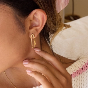 Boucles d'oreilles trombone dorées avec lettrage Love et zircons sur mannequin