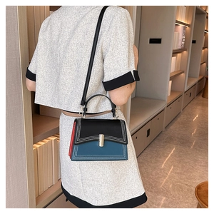 Détail d'un sac à main bandoulière chic avec design color-block bleu, noir et rouge
