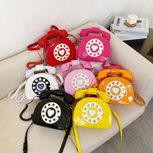 Top-down view of creative retro telephone crossbody bags in various patent leather colors