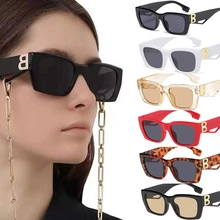 Detail of rectangular pink cat-eye sunglasses with luxury metal B logo on temples
