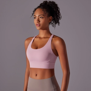 Dettaglio del reggiseno sportivo rosa con spalline larghe e leggings yoga grigi sul modello