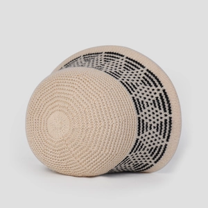 Macro shot of knitted bucket hat with black geometric pattern on cream wool fabric