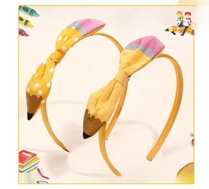 Close-up of pencil-shaped handmade fabric bows with yellow polka dots for girls
