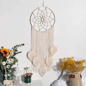 Detail of bohemian dream catcher with woven cotton leaves, wood beads and moon pattern
