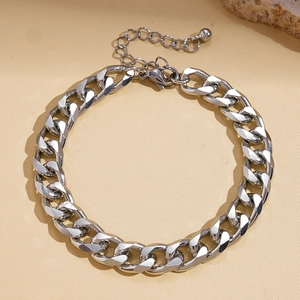 Detailed macro view of silver metallic curb link chain bracelet with lobster clasp