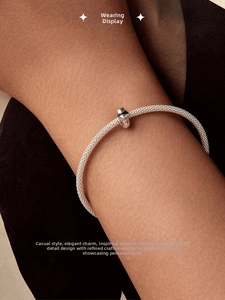 Close-up of a s925 silver mesh bracelet with a cute panda enamel charm on a woman's wrist