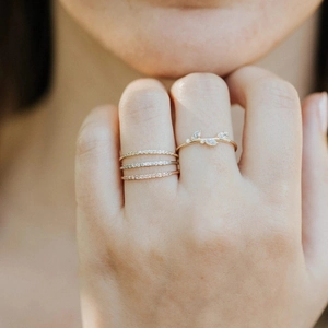 Close-up of gold layered eternity ring and leaf diamond ring on a hand for luxury banquet