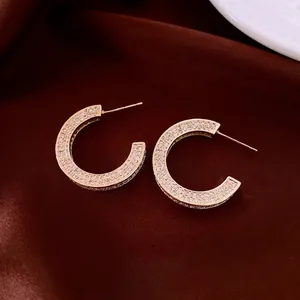 14k gold plated C-shaped earrings with micro-pave cubic zirconia on red velvet